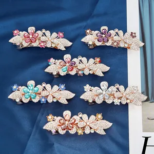Set of crystal flower hair clips with rhinestones and gold alloy base on blue silk