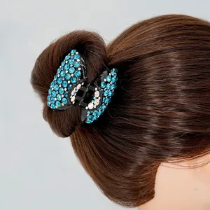 Pince à cheveux avec strass bleus présentée sur un chignon de cheveux bruns