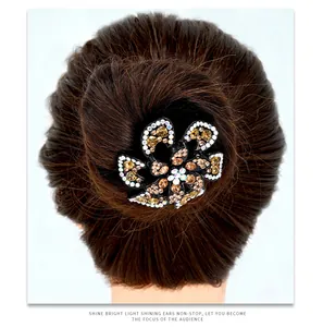 Detailed view of a flower hair claw clip with rhinestones worn on a stylish hair bun