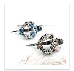 Detailed view of vintage crystal duckbill hair clips with blue and champagne rhinestones
