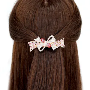 Fermaglio a farfalla traforato con cristalli rosa e strass su capelli castani