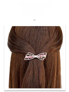 Vue détaillée d'une barrette nœud avec strass roses et blancs sur métal argenté