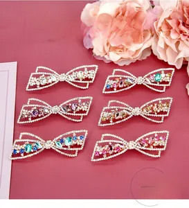 Vue détaillée des barrettes nœuds évidés avec des zircons colorés et des strass fins