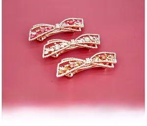 Détails de barrettes à nœuds en or rose serties de cristaux roses et blancs
