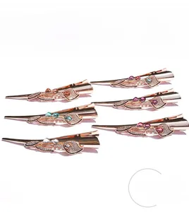 Close-up of six colorful crystal floral hair clips with sparkling rhinestones and metal plating
