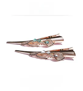 Detail showing rose gold duckbill hair clips with sparkling crystals and floral motifs