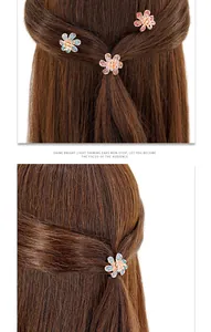 Vue détaillée des mini pinces à cheveux florales avec cristaux colorés sur cheveux bruns
