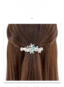 Détail d'une barrette à ressort en or rose avec pétales en résine et strass brillants