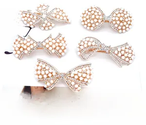 Détail de barrettes à cheveux en or rose avec perles blanches et cristaux étincelants