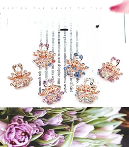 Detailed view of crown-shaped mini hair claws set with colorful shimmering crystals