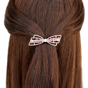 Barrette à cheveux nœud argenté avec cristaux roses sur cheveux bruns, vue de dos