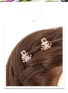 Macro detail of crown hair claw clip with purple rhinestones on rose gold metal