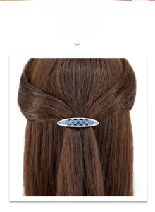 Detail of a blue crystal spring hair clip with rhinestones on a brown hair bundle
