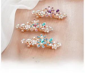 Détail de barrettes à fleurs en cristal avec perles sur fond de soie rose délicate