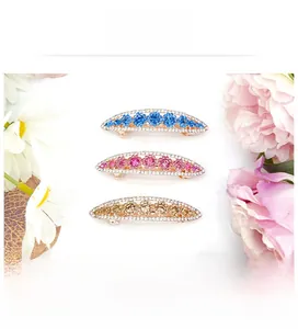 Detail of crystal flower hair clips with sparkling rhinestones in blue, pink, and gold