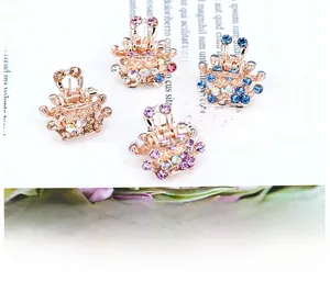 Detail view of four mini golden claw clips with colorful crystal rhinestones