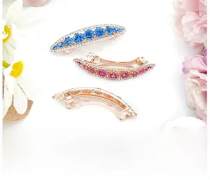 Detailed view of three rose gold flower hair clips with blue, pink and white crystals