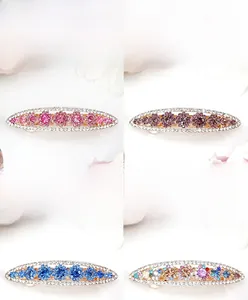 Detailed view of four colorful crystal hair clips with floral rhinestones and gold alloy bases
