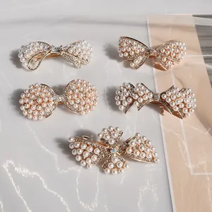 Ensemble de barrettes élégantes avec perles et cristaux sur fond de tissu blanc
