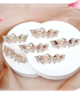 Detailed view of elegant butterfly hair clips with colorful rhinestones on silk