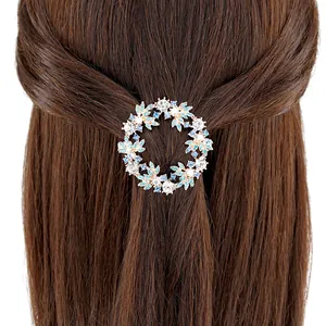 Floral crystal wreath hair clip with blue rhinestones worn on brown wavy hair