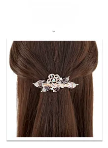Detailed view of floral crystal hair clip worn on brown hair showing size and sparkle