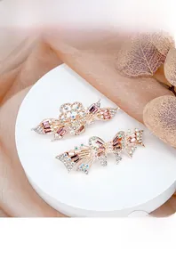 Detail of rose gold hair clip featuring crystal-encrusted hollow flower and bow design