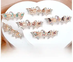 Detail of elegant bow hair clips with colorful crystals on a soft silk background