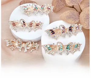 Close-up of rose gold hollow butterfly hair clips with sparkling colored rhinestones