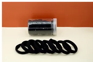 Detail of high-elasticity black seamless hair ties inside a clear storage bottle