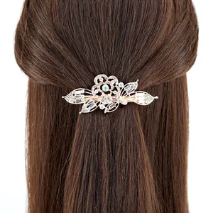 Elegant rose gold crystal flower hair clip with rhinestones worn on brown long hair
