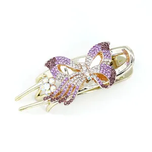Pince à cheveux papillon dorée avec strass violets et détails de fleurs en cristal