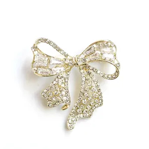 Élégante broche nœud doré sertie de strass étincelants et de cristaux brillants