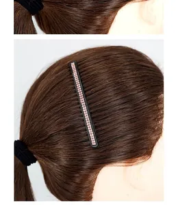 Detailed view of black hair comb with pink rhinestones styling a brown ponytail