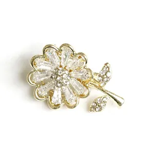 Eleganter goldener Blumenanstecker mit rechteckigen Zirkonia und funkelnden Kristallen