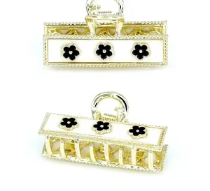 Detailed view of golden hair claw with vintage black and white floral patterns