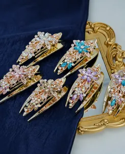 Détails de peignes à fleurs avec strass colorés sur un fond en velours bleu foncé