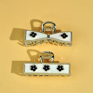 Elegant gold hair claw set with white pearl inlay and black clover floral patterns