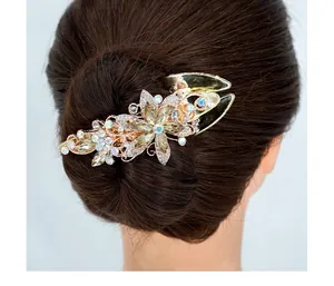 Détail d'une pince à cheveux fleurie dorée avec strass scintillants sur une coiffure relevée