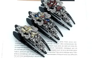 Detail of elegant black hair clips with sparkling crystal flower and tassel design