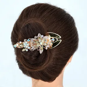 Pince à cheveux fleur dorée avec cristaux verts portée sur un chignon élégant