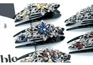 Detailed close-up of rhinestones and silver floral patterns on vintage duckbill hair clips