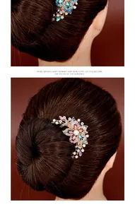 Detail of floral hair comb featuring colorful rhinestones and a central pearl on gold alloy