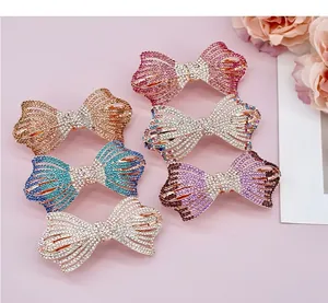 Détail de barrettes à nœuds en strass brillants aux multiples couleurs dégradées