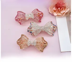 Détail de trois barrettes à nœuds en alliage serties de strass brillants de luxe