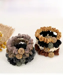 Detail of mesh hair scrunchies featuring a sparkling rhinestone ball ornament in four colors