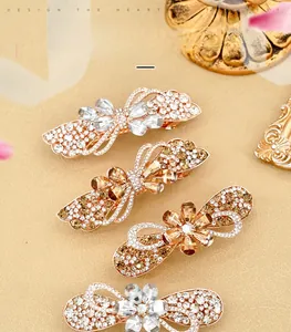 Detail showing four sparkling rhinestone flower hair clips in champagne and silver tones