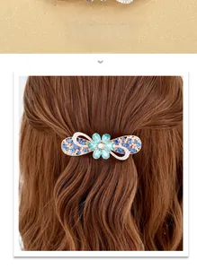 Detail of flower hair clip with blue rhinestones and gold alloy ribbon patterns