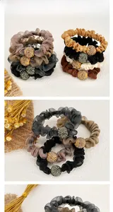 Detailed view of mesh scrunchies featuring rhinestone ball accents in earthy tones