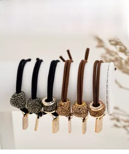 Détail d'élastiques à cheveux strass avec pendentifs cœurs sur support blanc